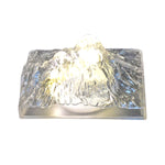 The Iceberg Night Light placed on a wooden surface, emitting a warm, ambient glow.