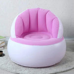 Child happily sitting on a bright yellow Kids Inflatable Sofa Chair with backrest.