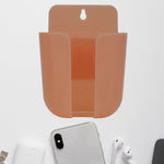 Wall mounted phone holder with a charging port in a modern living space.