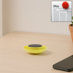 Yellow circular magnetic button gripping whiteboard surface