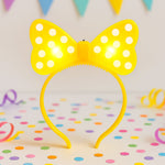Front view of LED glowing bow hairband with polka dots for kids