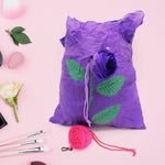 Unfolded reusable shopping bag featuring a vibrant rose design against a plain background.