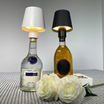 The versatile LED bottle lamp illuminating various colored wine bottles.