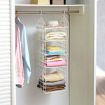 Various clothes, including pants and shirts, neatly hung on the different tiers of the folding clothes hanger.