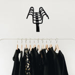 Versatile metal hanger rack holding kitchen utensils and towels.
