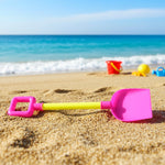 Kids beach sand shovel toy next to colorful sand bucket