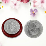 Side view of the round Ganesh coin, highlighting its silver-colored finish.