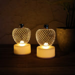 Three apple LED tealight candles creating a warm, ambient glow in a room.