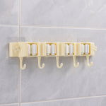 Self-adhesive broom and mop holder rack mounted on wall with utility hooks