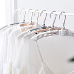 Adjustable arms of the folding clothes hanger demonstrated.
