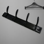 Top-down view of the 4-hook wall mount coat hanger holding various coats and hats.