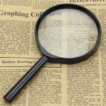 Worko magnifying glass for reading resting on printed pages, showing its compact size.