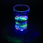 LED Light Glass illuminating a beverage with vibrant colors in a dark setting.