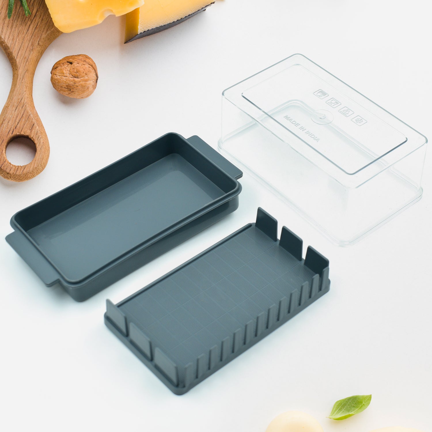 A block of butter being sliced inside the Butter Slicer Box, demonstrating the integrated cutter.