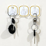 Close-up of a clear plastic transparent adhesive hook with a stainless steel hook.