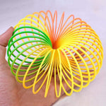 The Rainbow Slinky Toy in its compact, coiled form, displaying its mesmerizing colours.