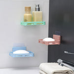 Self-adhesive wall-mounted soap holder installed in a shower for easy access to soap.