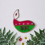 Close-up of diya shaped Shubh Labh wall hangings with golden borders and vibrant colors