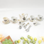 Miniature plastic cups, saucers, and spoons arranged for a pretend tea party.