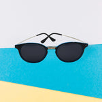 Classic UV Protected Round Sunglasses on a flat surface, emphasizing their lightweight feel for casual wear.