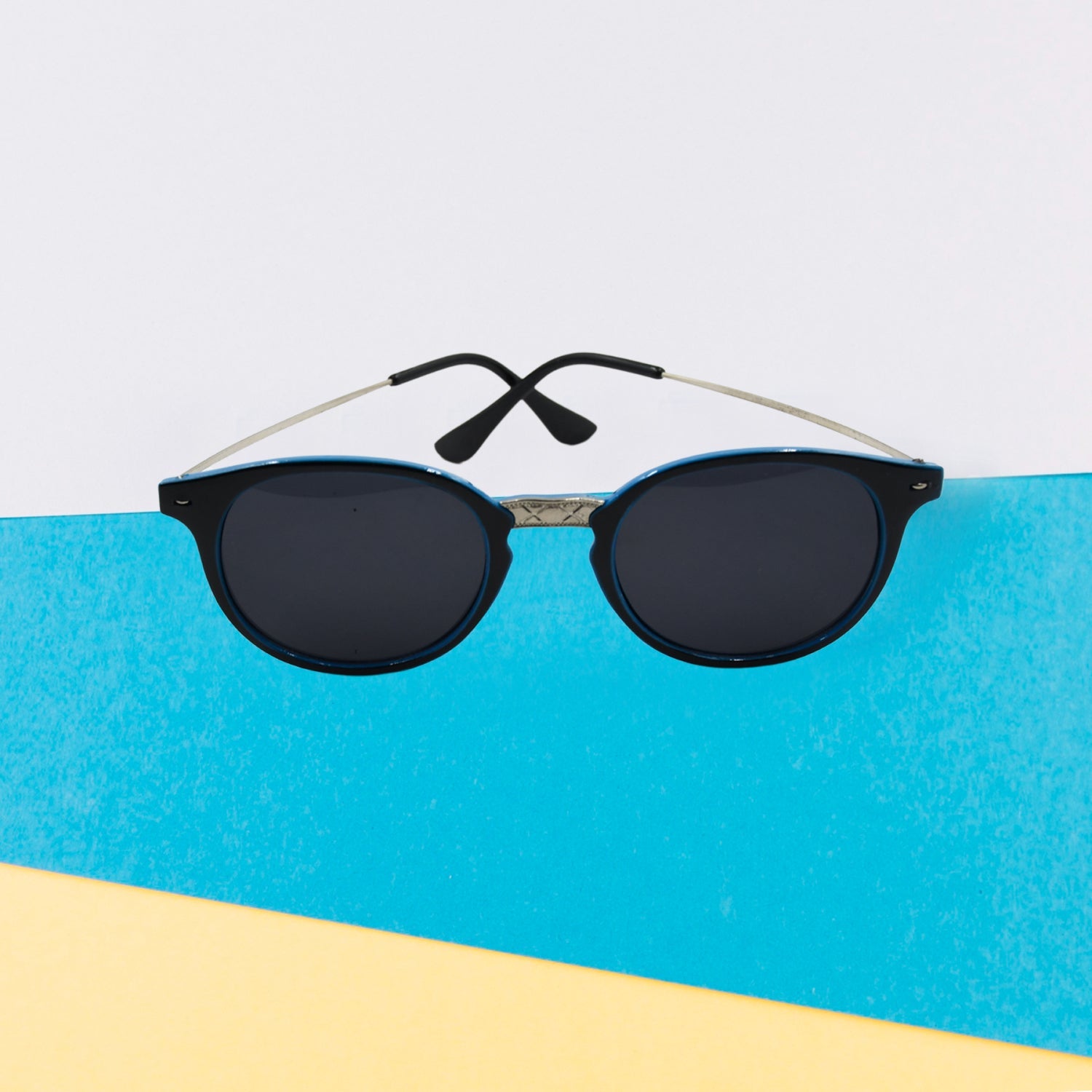 Classic UV Protected Round Sunglasses on a flat surface, emphasizing their lightweight feel for casual wear.