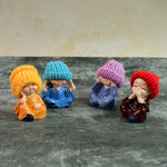 Four resin monk Buddha mini statues arranged side-by-side showcasing traditional poses