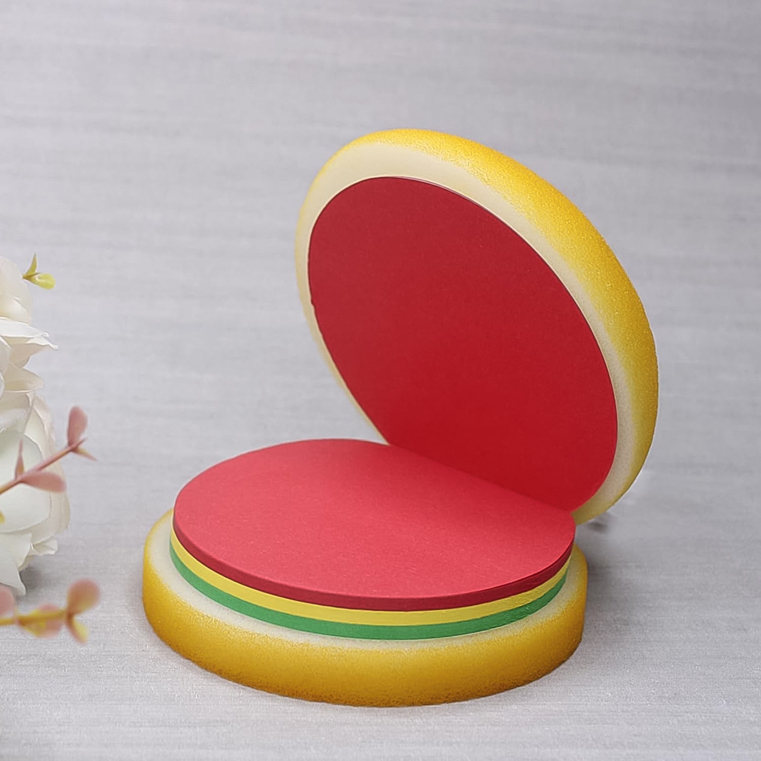 Hand writing a quick note on a Burger Shaped Sticky Note, highlighting its practical use.