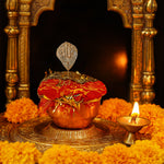 Side view of decorative copper-style mini kalash with traditional pooja accessories
