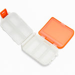 Top-down view of orange portable pill organizer with transparent lids