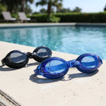 Pair of swimming goggles laid out on white background, highlighting design for clear underwater vision