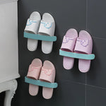 The self-adhesive towel rack effectively holding two bath towels and a pair of slippers.