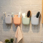 Mobile holder attached to wall socket for charging and accessory storage