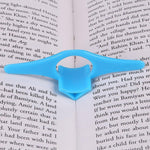 Person comfortably reading a book held open by the plastic thumb page holder.