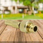 The brass water spray gun securely attached to a garden hose, ready for action.