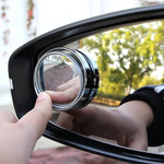 Close-up of round blind spot mirror on car