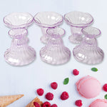 Clear plastic serving bowls displayed with various fruits and snacks.