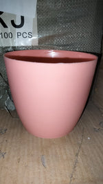 Round plastic planter in a modern indoor setting, demonstrating its versatility.