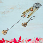 Vivid dragonfly wind chimes hanging outdoors in sunlight