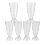Transparent plastic milkshake glasses neatly arranged on a dining table