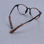 Silicone ear grips attached to eyeglass arms, demonstrating how they prevent glasses from slipping.