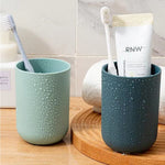 Multipurpose wall mount holder neatly storing toothbrushes, toothpaste, and cups, enhancing bathroom organization.