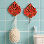 A GlimmerHome wall hook holding a pair of scissors, demonstrating its versatile use.
