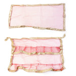 Red pooja cloth with gold border wound as net wrap for tulsi plant adorning