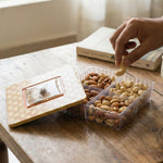 Opened plastic storage container showing four sections for dry fruits