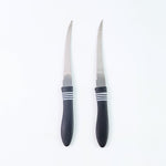 Serrated knife set placed on cutting board with vegetables for kitchen prep