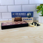 Foldable chess board displaying magnetic plastic pieces in play