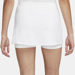 Model running in a white high-waisted athletic skort outdoors.