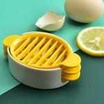 A hand using the plastic egg slicer to create perfect, even slices of a boiled egg.