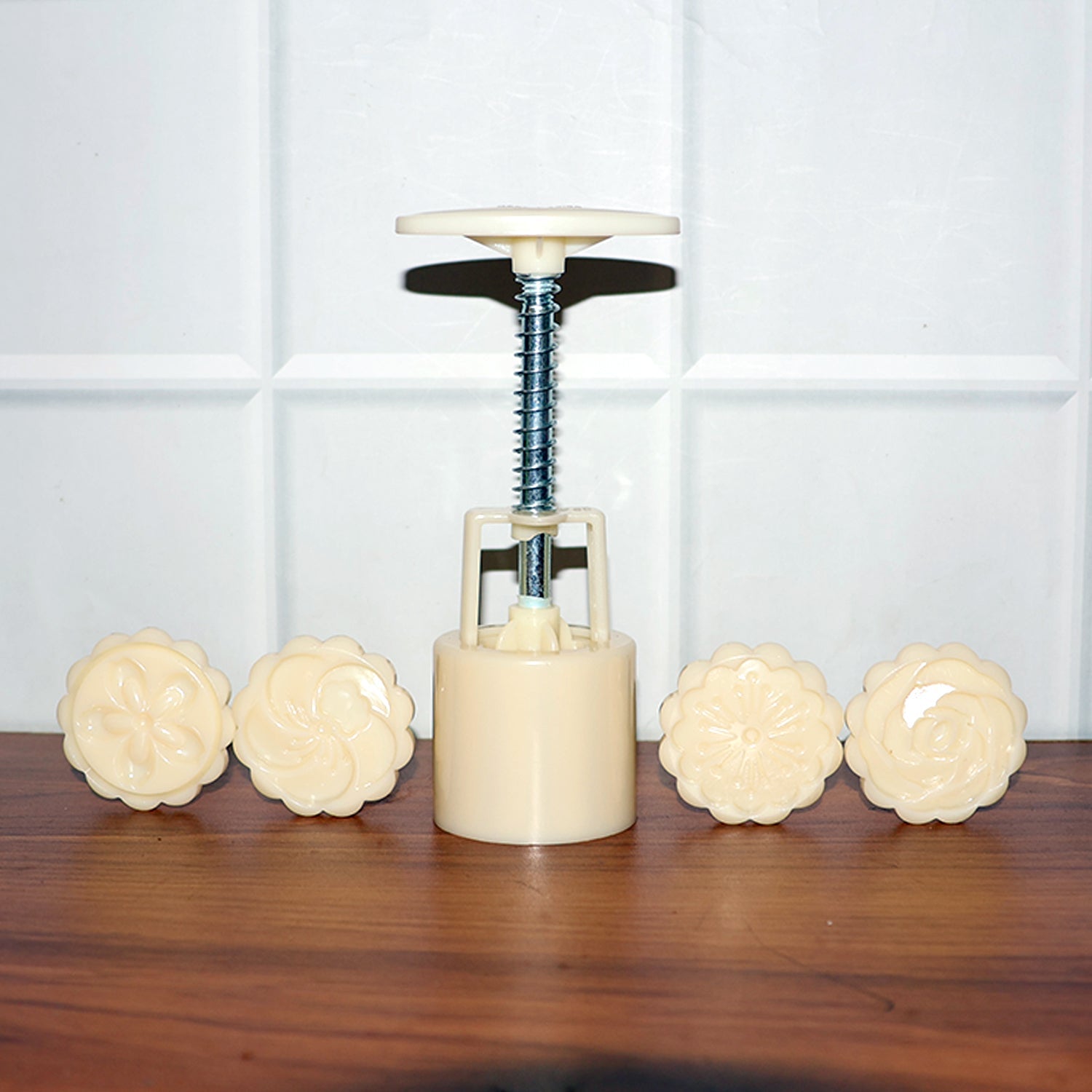 Components of spring press cookie and pastry mold set laid out for assembly
