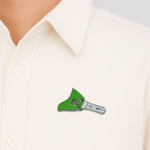 Close-up of metal badge pin attached on fabric showcasing enamel detail